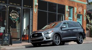 A 2020 silver INFINITI QX60 parked in front of a music shop. | INFINITI dealer in Ellisville, MO